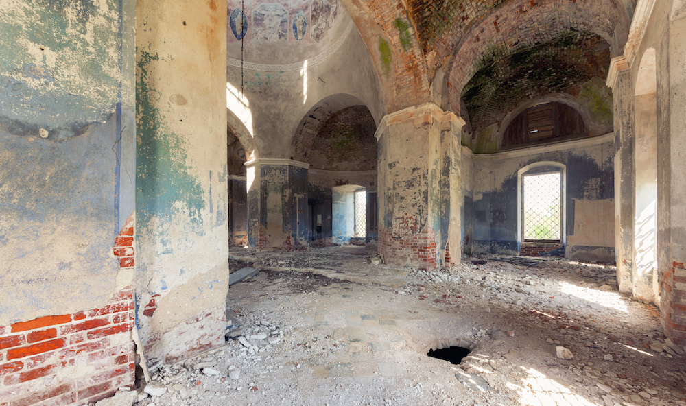 Inside an abandoned looted temple. Columns and a dome with crumbling paint and plaster Inside an abandoned looted temple. Columns and a dome with crumbling paint and plaster
