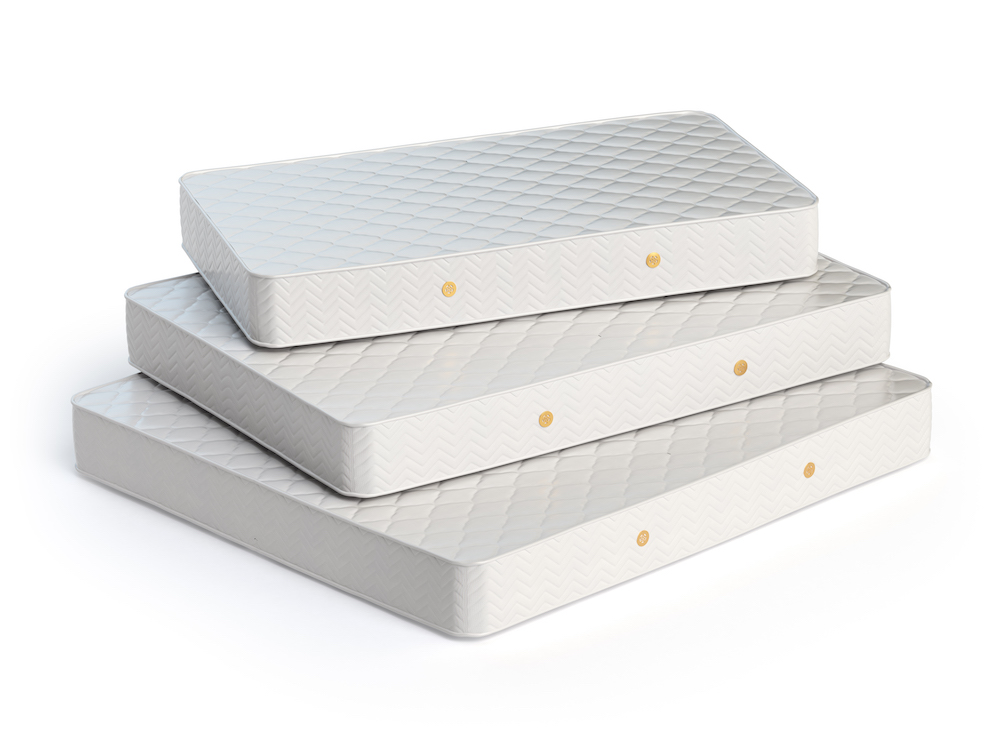 Mattress isolated on white background. Stack of orthopedic mattresses of different sizes.