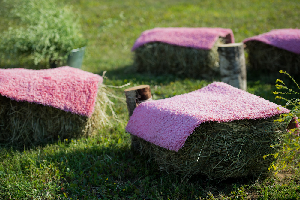 Seats made of straw hay and pallet wood covered with violet carpet