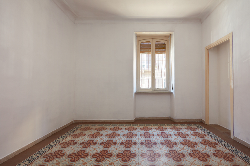 Empty room interior with tiled, decorated floor in a sunny day