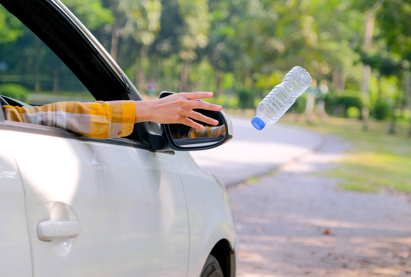 Woman Throwing Out Plastic Bottle from Vehicle